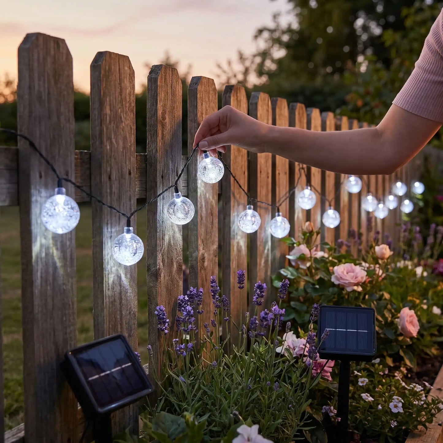 main femme place guirlande exterieur solaire microbulles blanches clôture