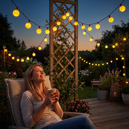 femme admire guirlande exterieur solaire globe opaque jardin magique