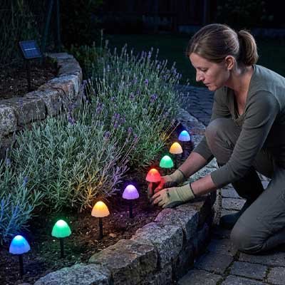 femme guirlande lumineuse extérieur solaire champignons multicolores bordure jardin